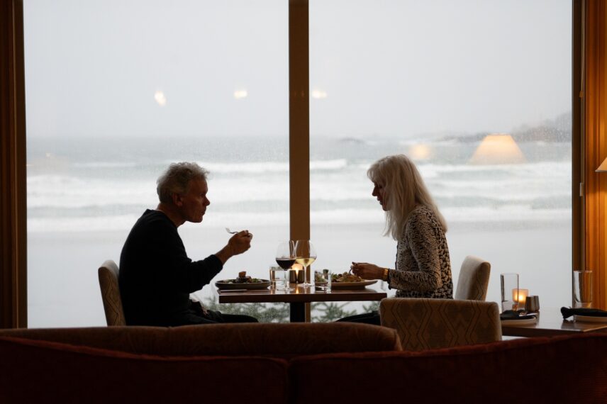 Romantic meal for two at a window table in the Great Room, with dramatic ocean waves outside.