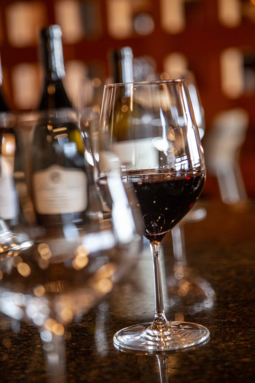 Wine glasses lined up on a bar counter